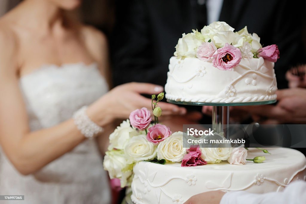 Bride And Groom Cutting Cake A bride and a groom is cutting their wedding cake Wedding Cake Stock Photo