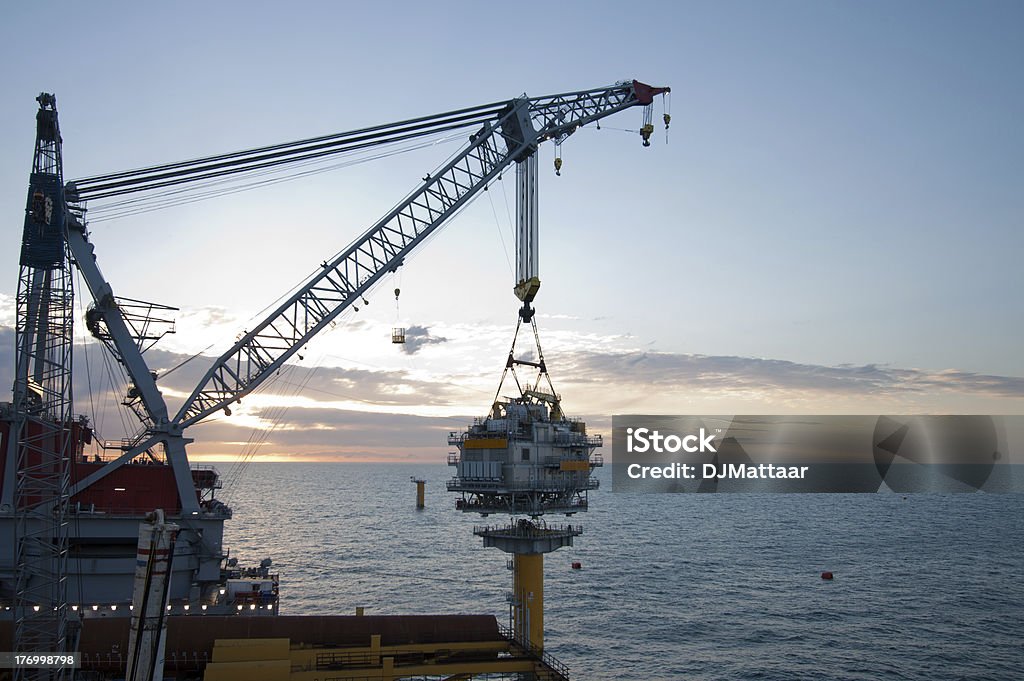 Windfarm construction Large crane vessel installing a transformer platform in a windfarm under construction of the UK coast Sea Stock Photo