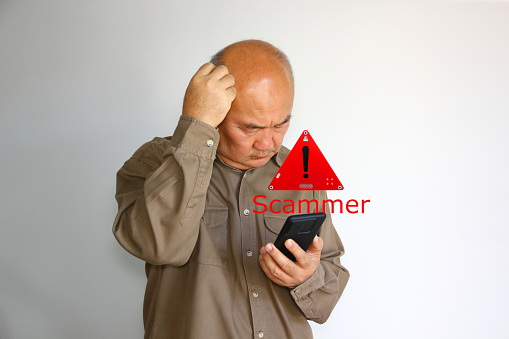 Asian senior man has using smart phone  but  his phone was scammer. warning sign scammer on mobile phone