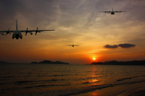 istock C130 HERCULES flying above sea on sun set time 1769989028