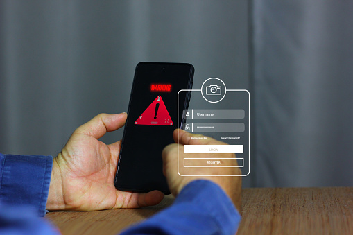 warning signal for mobile phone being attacked . man registering his mobile phone change password protec his phone from hacher