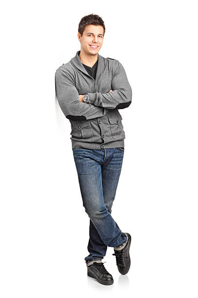 Happy young man leaning against wall