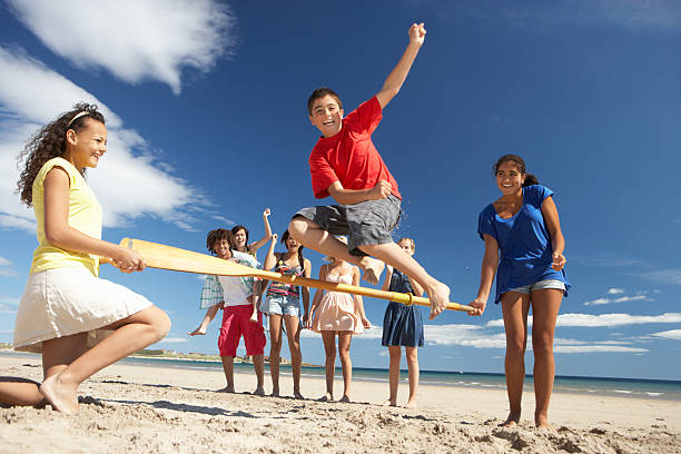 Diverse group of young friends enjoying a fun moment on the beach, laughing together. summer lifestyle, freedom, and multicultural friendship.