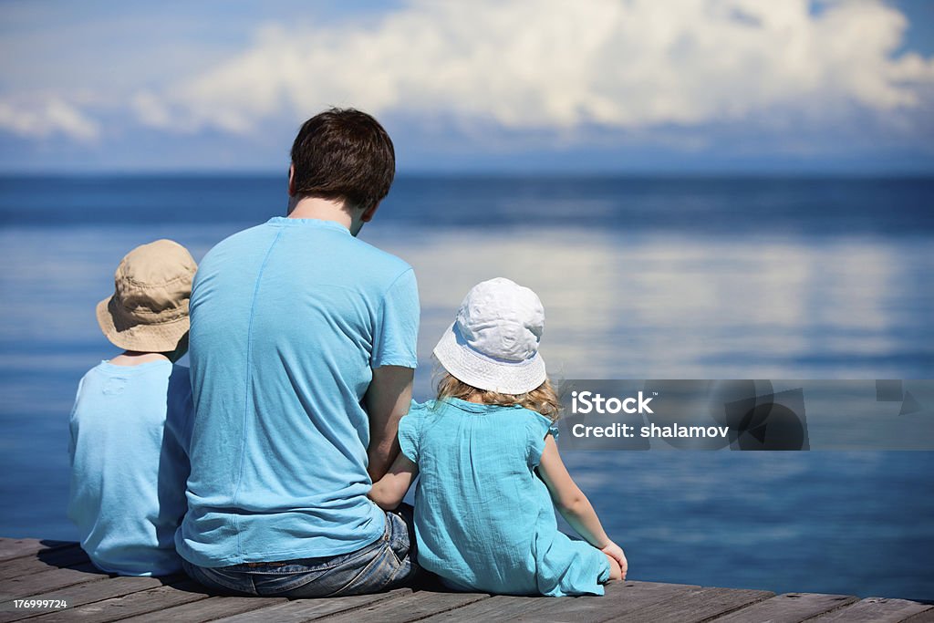 Padre y Niños ubicado en el muelle de madera - Foto de stock de Adulto libre de derechos