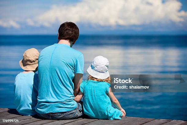 Father And Kids Sitting On Wooden Dock Stock Photo - Download Image Now - Adult, Boys, Brother