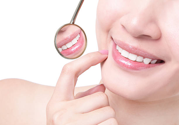 istock Woman's healthy smile with a dentist mirror 177000278