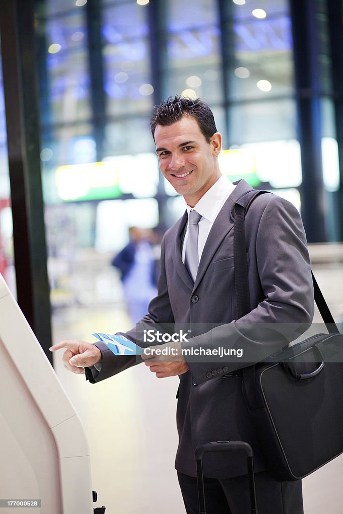 Empresário usando a máquina de autoatendimento de check-in no aeroporto - Foto de stock de Aeroporto royalty-free