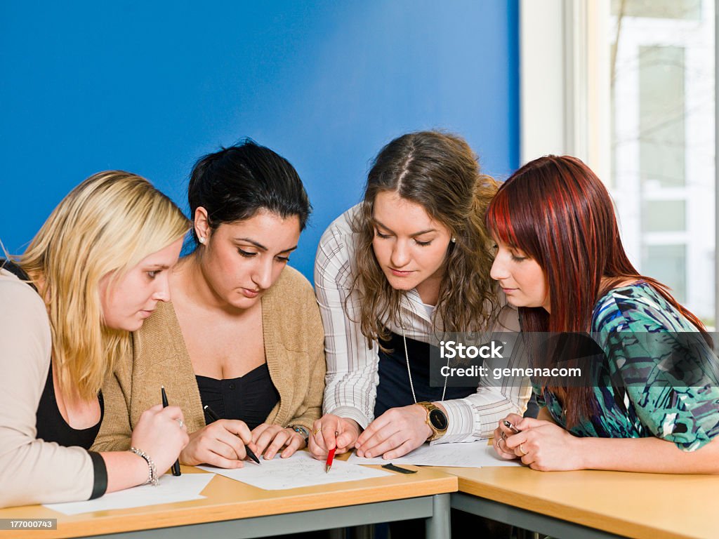 College students working on a group project Four girls groupwork in the classroom Adolescence Stock Photo