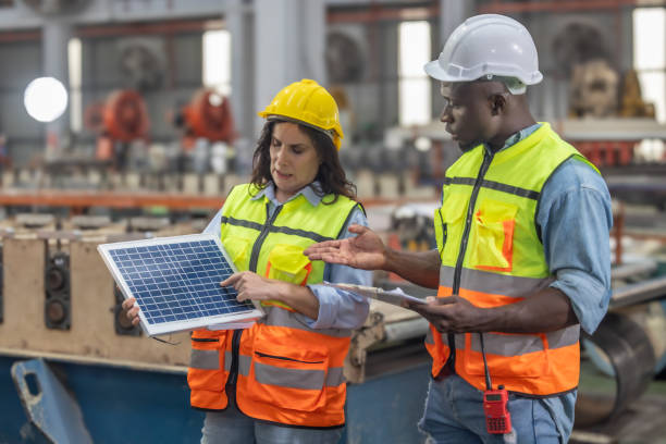 los trabajadores metalúrgicos de las fábricas instalan paneles solares, reducen costos, ganan créditos de carbono, combaten el cambio climático. - budget green business finance fotografías e imágenes de stock