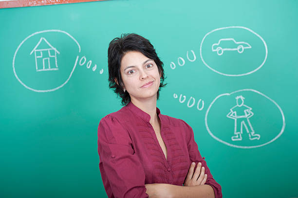 Woman standing in front of a blackboard stock photo