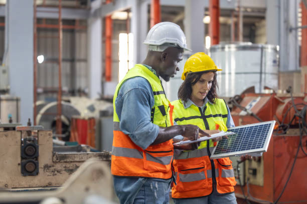 los trabajadores metalúrgicos de las fábricas instalan paneles solares, reducen costos, ganan créditos de carbono, combaten el cambio climático. - budget green business finance fotografías e imágenes de stock