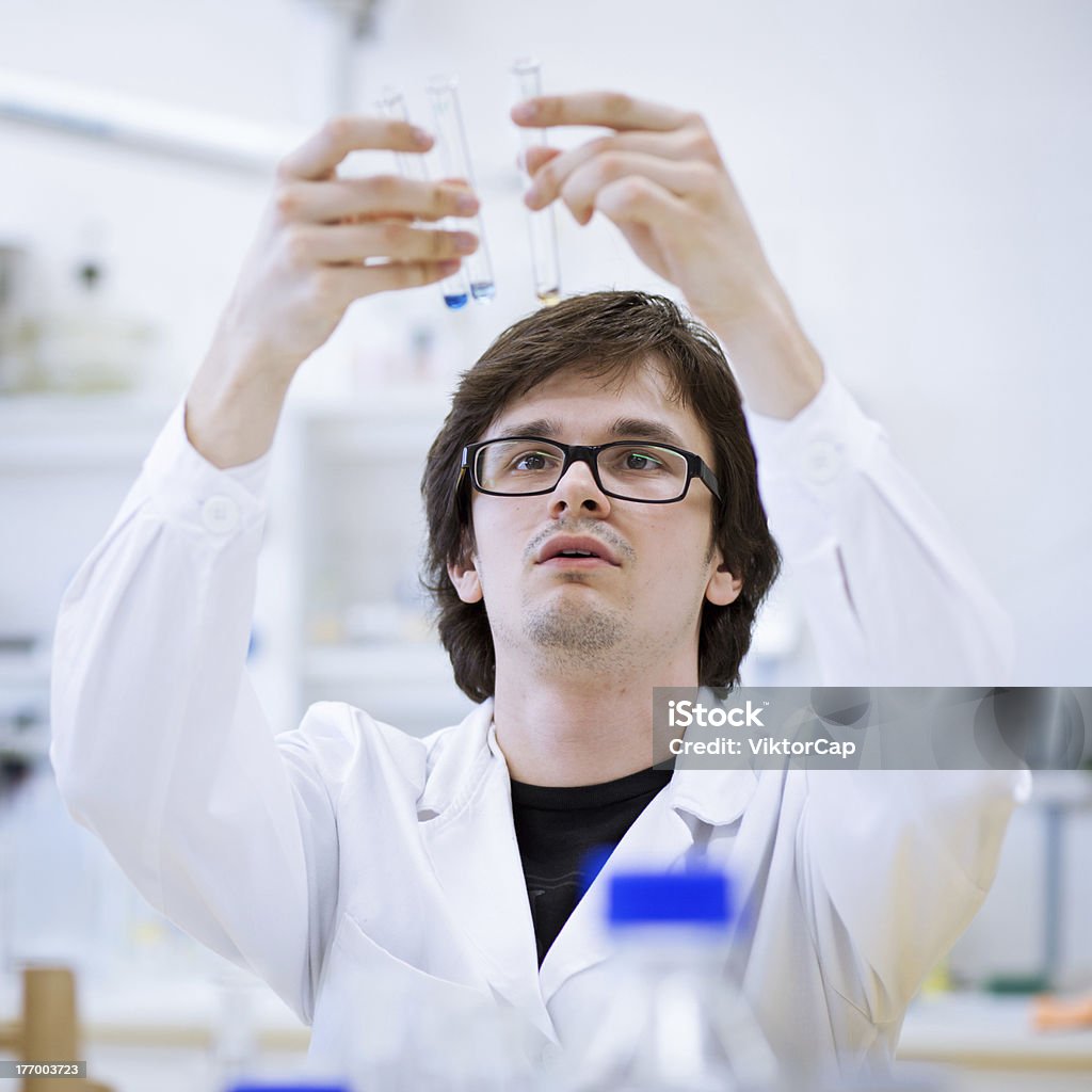 young male researcher carrying out scientific research "young, male researcher/chemistry student carrying out scientific research in a lab (shallow DOF; color toned image)" Adult Stock Photo
