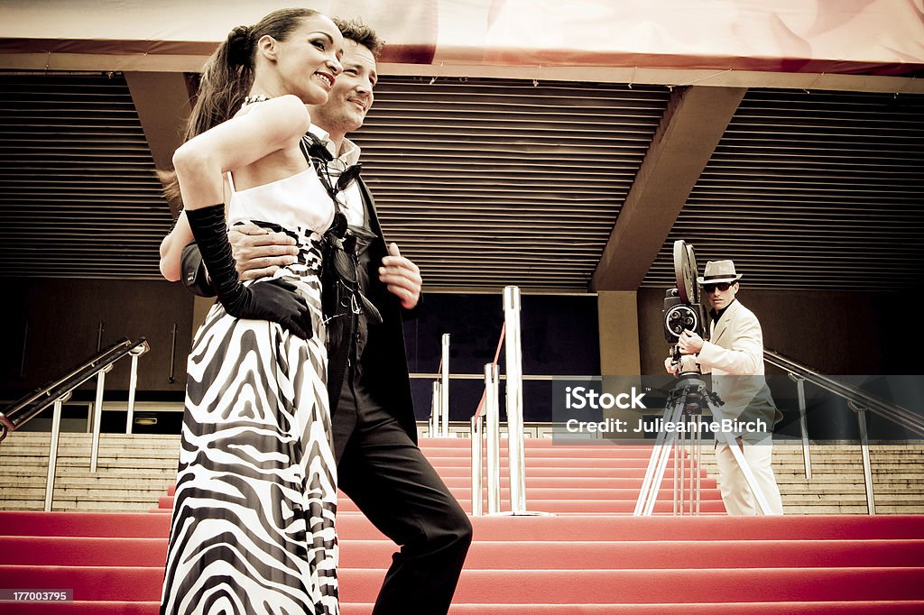 2 movie celebrities posing on red staircase Two models pose on red carpet with camera man in background, Cannes Istockalypse International Cannes Film Festival Stock Photo