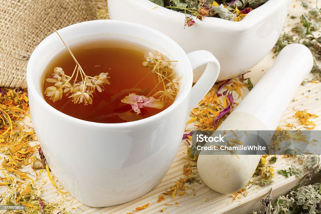 cup of healthy tea, mortar and pestle with healing herbs cup of healthy tea, mortar and pestle with healing herbs on wooden table, herbal medicine Alternative Medicine Stock Photo