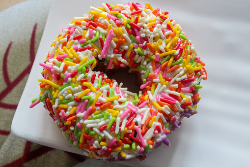 a donut with colorful sprinkles on a plate