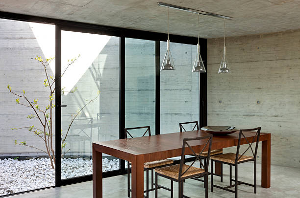 istock Long narrow wooden table with four chairs next to windows 177004639