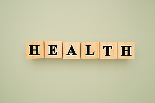 Top view of wooden cubes with words HEALTH on a green background. Medical and health concept