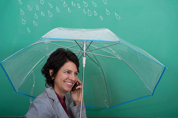 Young woman standing in front of blackboard holding an umbrella stock photo