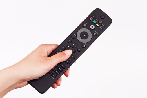 remote controller in hand of woman and pushing button