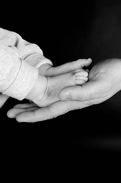 Baby feet in Father's Hand stock photo