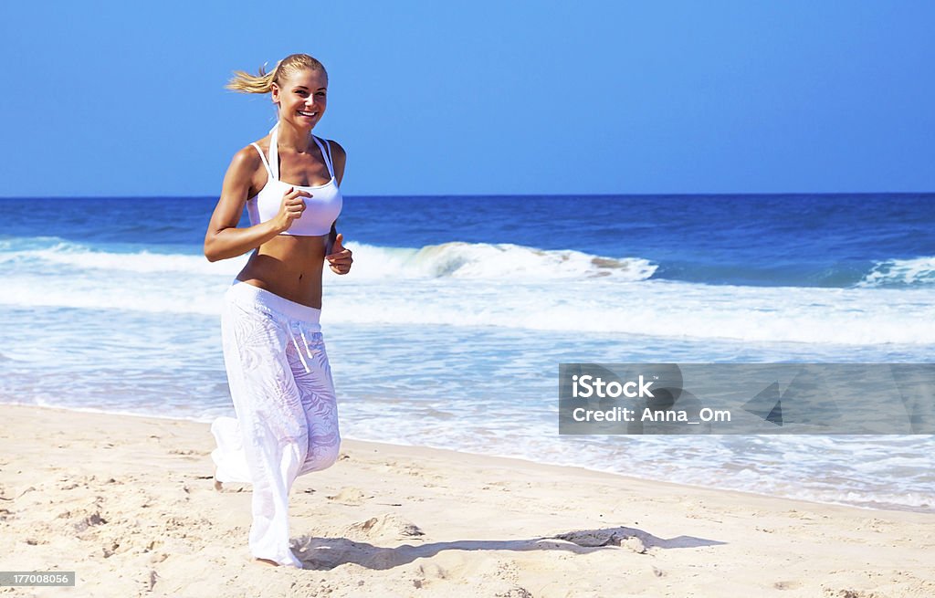 Saine femme jogging sur la plage - Photo de Activité libre de droits