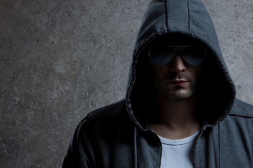 Portrait of urban looking man with sunglasses and hoodie