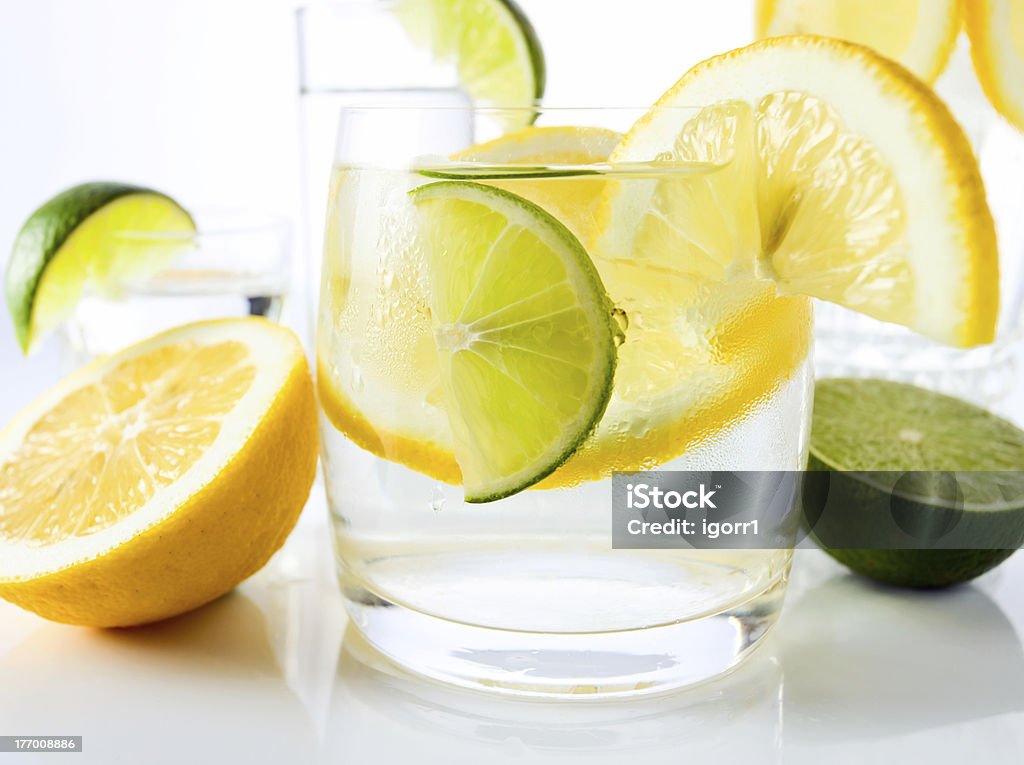 drinks with lemon and lime. drinks with lemon and lime, shot on reflective white background. Alcohol - Drink Stock Photo