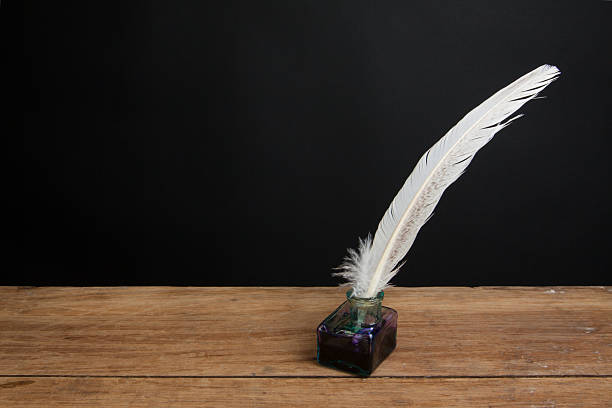 istock Quill ink pen and inkwell on wooden table 177009975