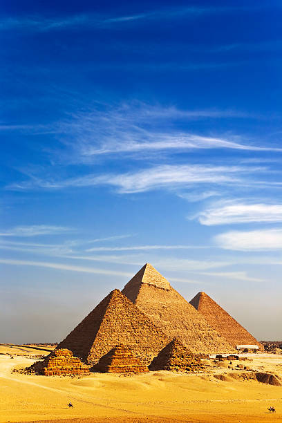 Pyramids at Giza under a blue sky with light cloud Egypt. Cairo - Giza. General view of pyramids from the Giza Plateau (there is three pyramids popularly known as Queens' Pyramids on front side; next in order from left: the Pyramid of Menkaure /Mykerinos/, Khafre /Chephren/ and Chufu /Cheops/ - known as the Great Pyramid). The Pyramid Fields from Giza to Dahshur is on UNESCO World Heritage List khafre photos stock pictures, royalty-free photos & images