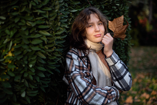 Autumn portrait of a teenage girl in the park