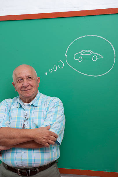 Hispanic senior standing in front of a blackboard stock photo