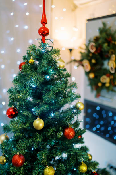 istock Christmas tree with a red icicle-top is decorated with sparkling garlands and multi-colored balls 1770111373