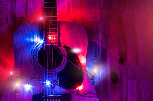 Classic Acoustic Guitar in christmas holiday lights background. Holiday night concept