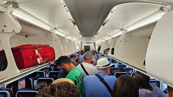 Istanbul, Turkey - 07 July 2023: Interior of an airplane with passengers standing on foot to depart the plane after landing.