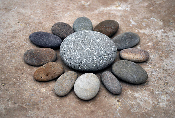 Different textured stones creating a flower shape. Marble background.
