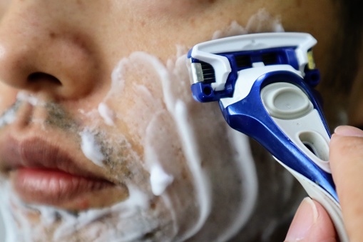 Close-up of a Japanese man shaving his beard