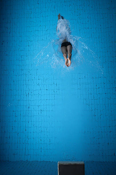 diving in pool man diving into blue pool water diving board stock pictures, royalty-free photos & images
