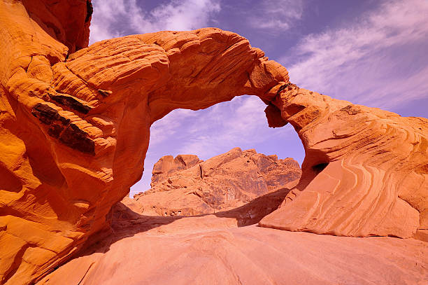A natural arch seen in Valley of Fire during a hot day in the hot desert landscape in Nevada, USA.