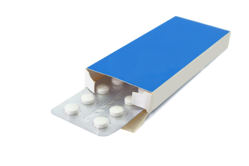 Pills tablets in open package on white background