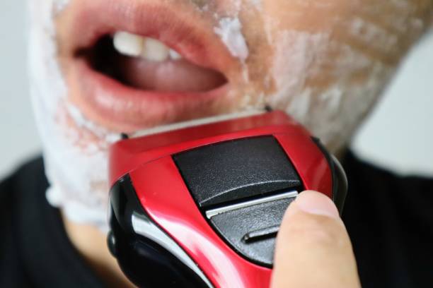 Close-up of a Japanese man shaving with an electric razor