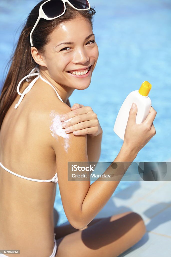 Sunscreen woman "Sunscreen xwoman putting solar cream or sunblock smiling happy in bikini by pool. Beautiful young xwoman under the sun on sunny summer day, Mixed race Asian / Caucasian girl." Nature Stock Photo