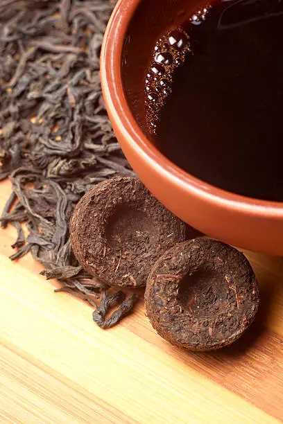 Photo of The cup of pu-erh and two bricks