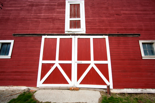 The front part of a red barn with bright white trim.
