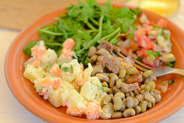 BBQ Salads "Plate with traditional Brazilian side dishes - potato salad, black eyed pea salad, tomato and onion salsa and coriander." banchan stock pictures, royalty-free photos & images
