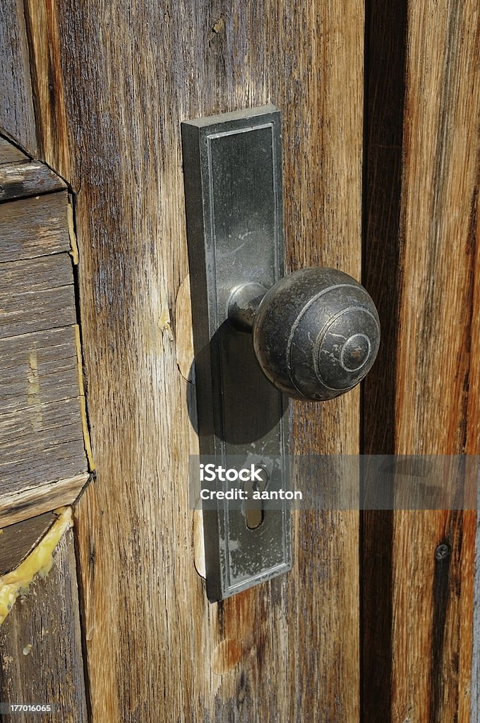 Old doorknob An old doorknob at an old wooden front door Front Door Stock Photo