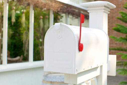 a closed white mailbox with red flag up.