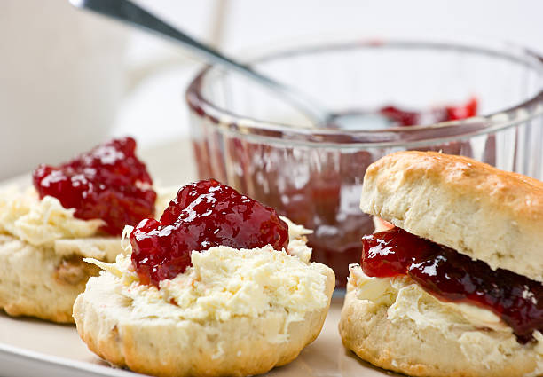 des scones avec de la confiture de fraises et crème épaisse. - biscuit au babeurre photos et images de collection