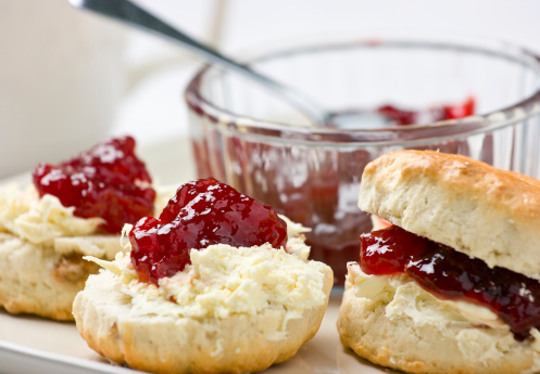 Home-baked scones tea with strawberry jam and clotted cream. Shallow depth of field.For similar photos please check out my