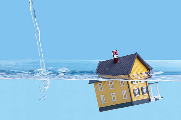 A miniature house sinking in the water