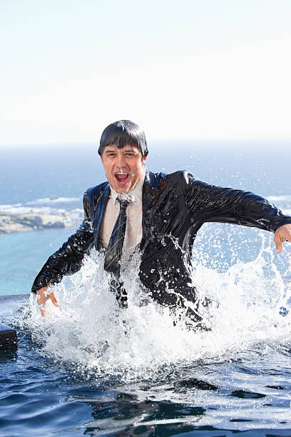 Portrait of a businessman going out from the pool Portrait of a businessman going out of the water in a swimming pool soaked suit stock pictures, royalty-free photos & images